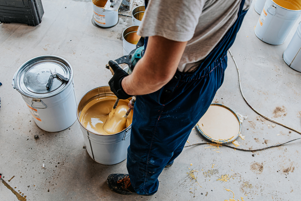 Worker,Mixing,Yellow,Epoxy,Resin,With,The,Mixer,In,A